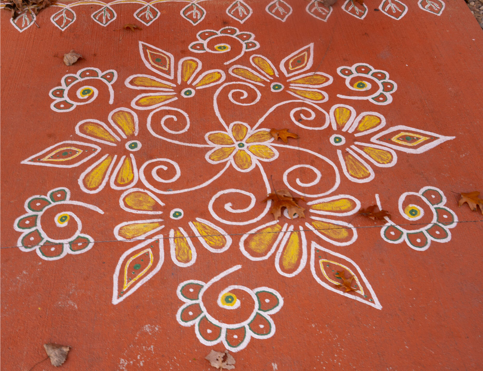 A symmetrical chalk drawing with flowers on the ground